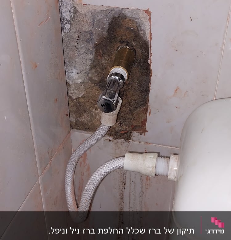 צינור מים מחובר לשסתום בקיר חדר אמבטיה